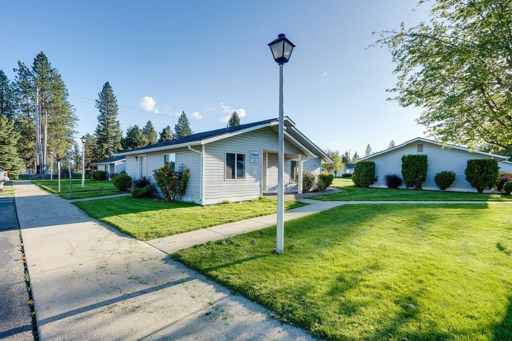 a white house with a lamp post on the side of a sidewalk