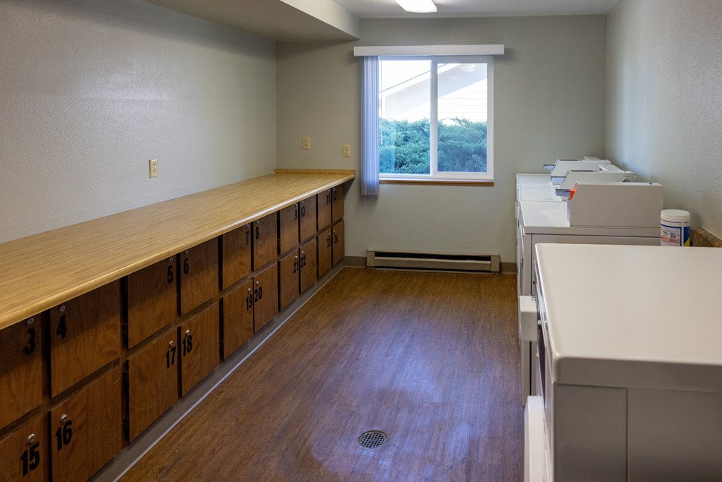 A room with a long wooden table and drawers on the side.