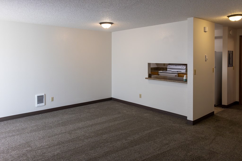 A room with a carpeted floor and a picture frame on the wall.