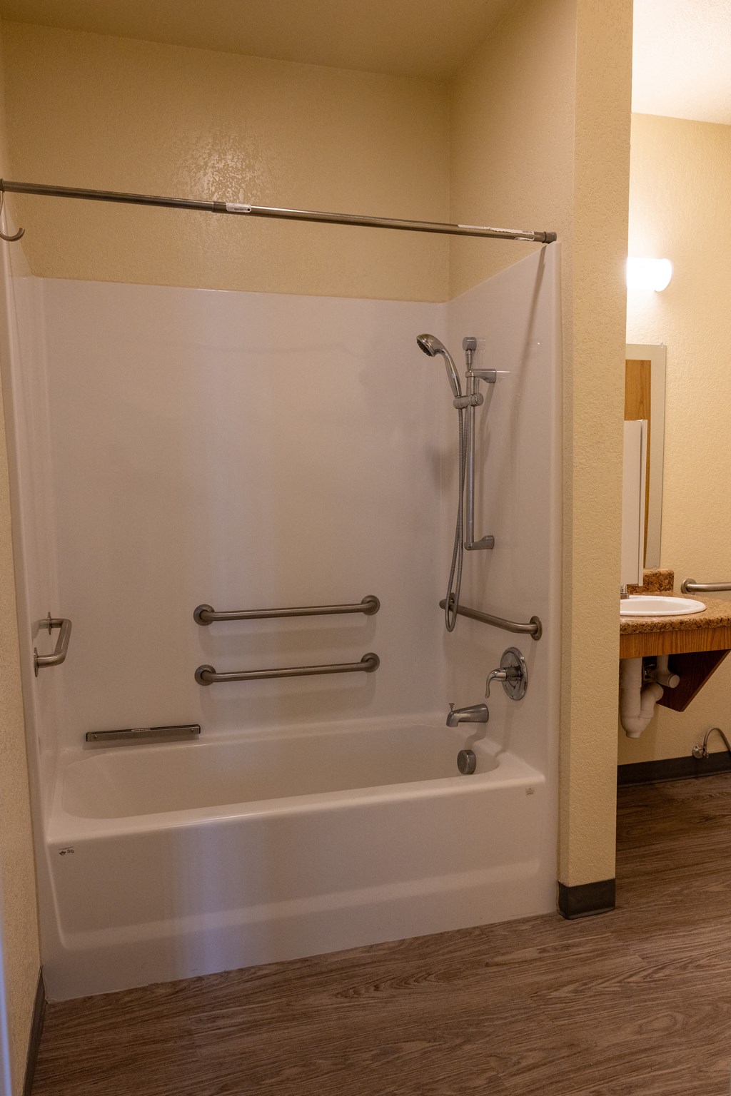 A white bathtub with a shower head and hand held shower.