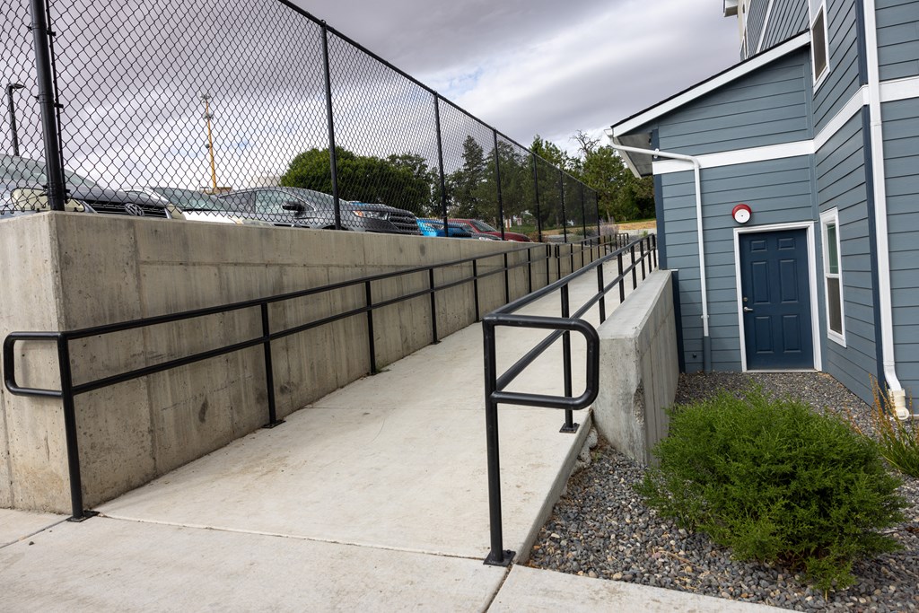 A blue building with a black fence and a red circle on the door.