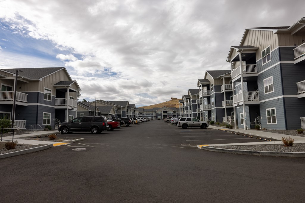 A street view of a residential area with cars parked on the side.