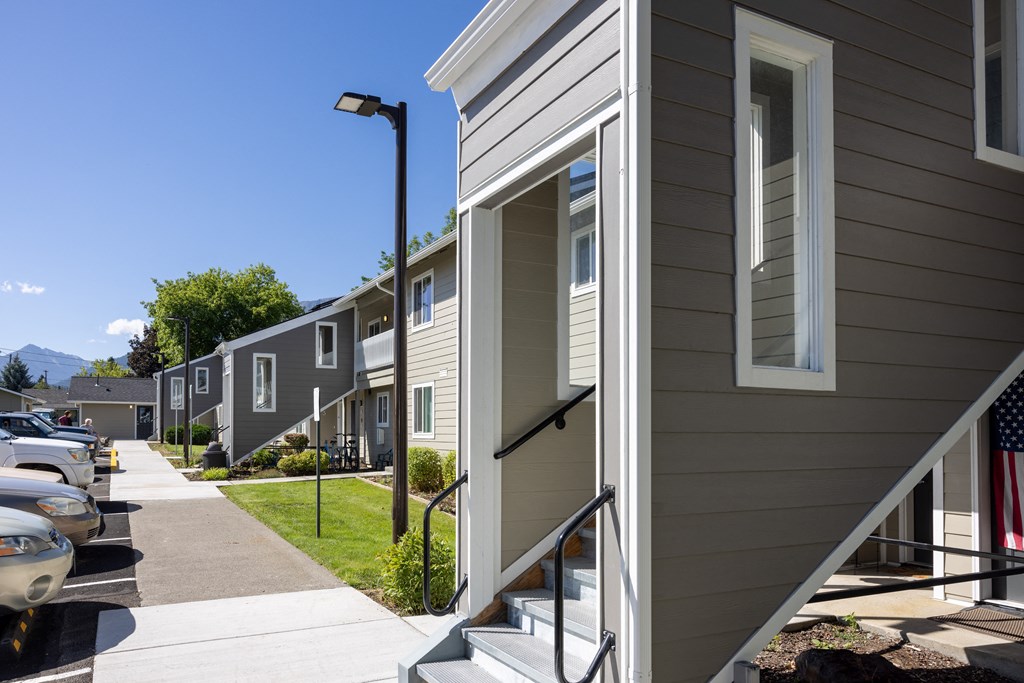 a row of houses on the side of a sidewalk