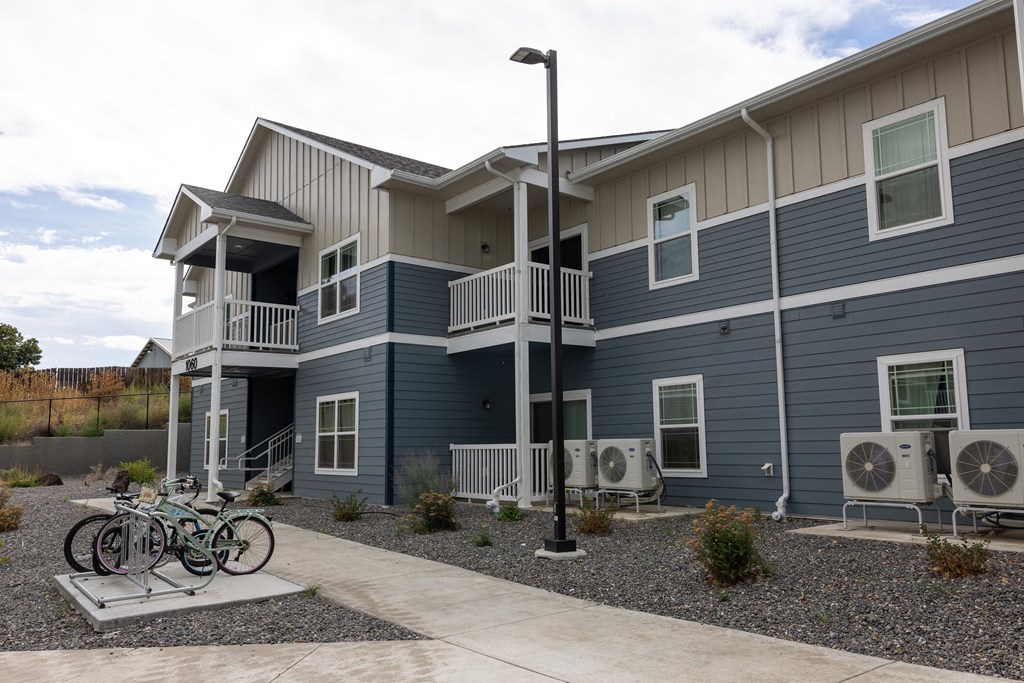 A two-story building with a balcony and a bicycle parked in front.