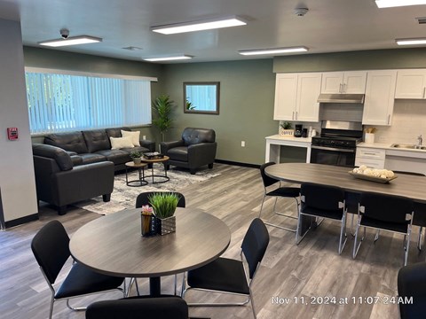 A modern living room with a dining area and kitchen in the background.