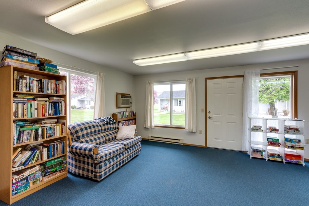 a library with a couch and a bookshelf full of books