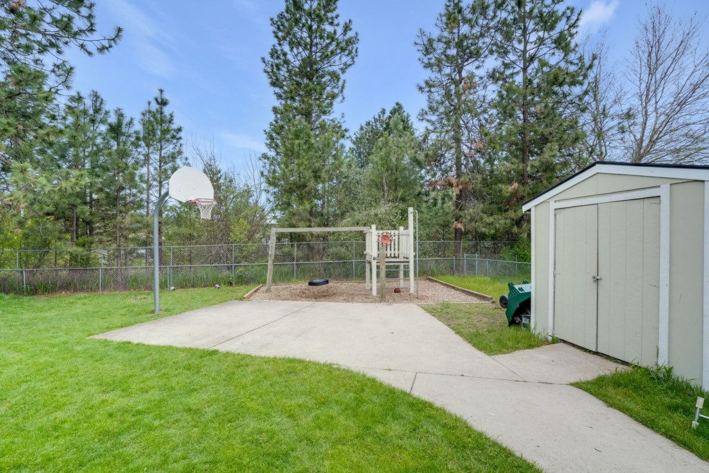 the backyard has a basketball court and a shed with a basketball hoop