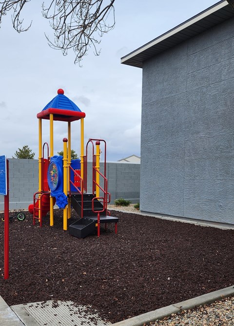 A playground with a blue and yellow structure.