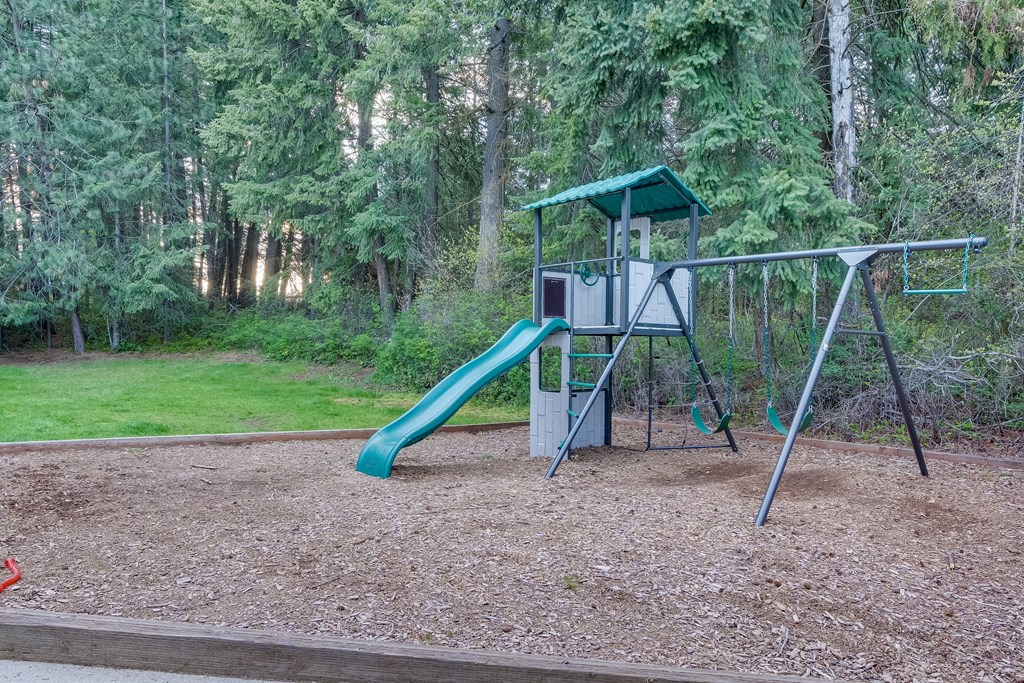 a swing set with a slide in a park