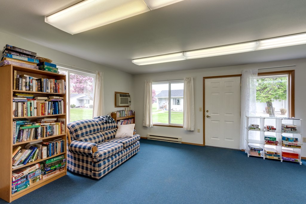a library with a couch and a bookshelf full of books