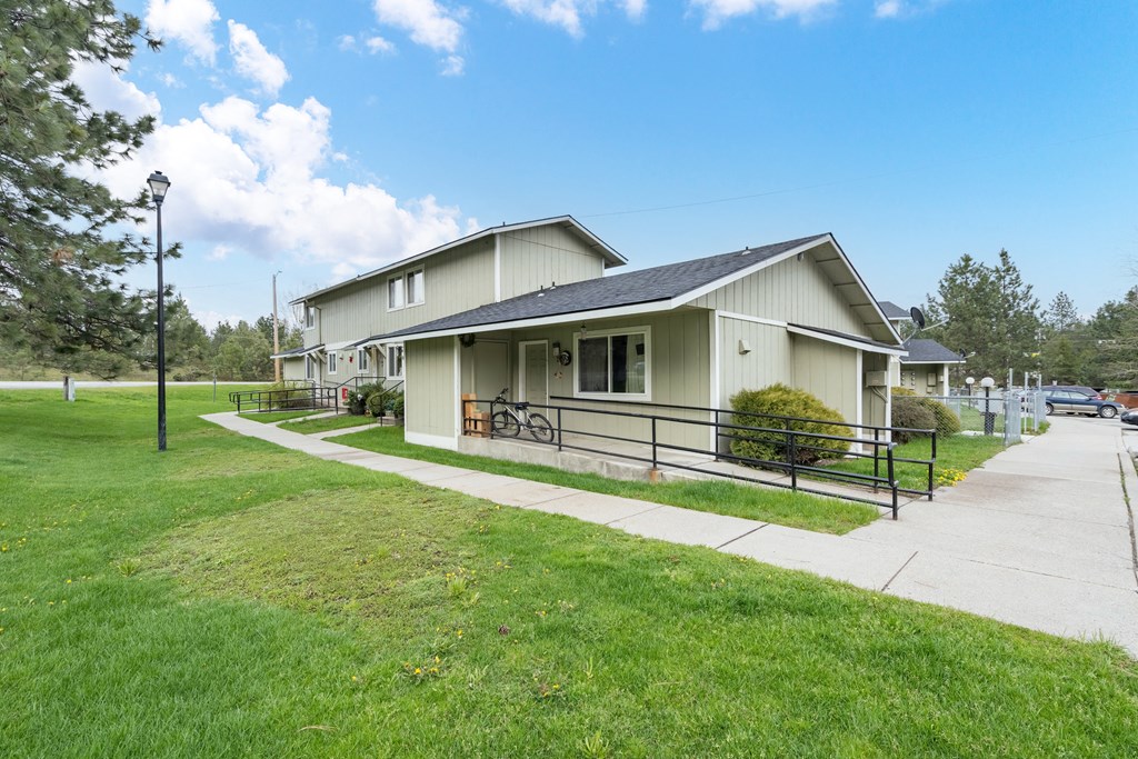 the front of a house with a sidewalk and a lawn