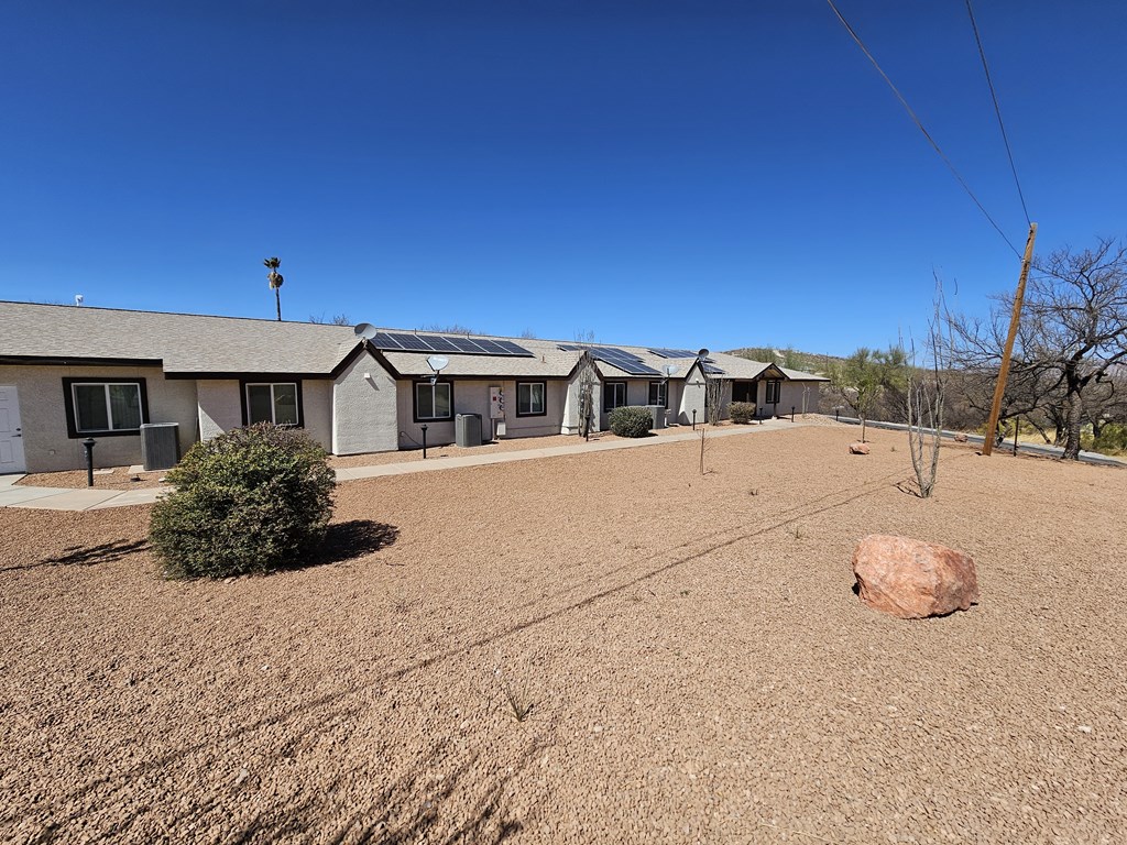 A large rock sits in the middle of a dirt field.