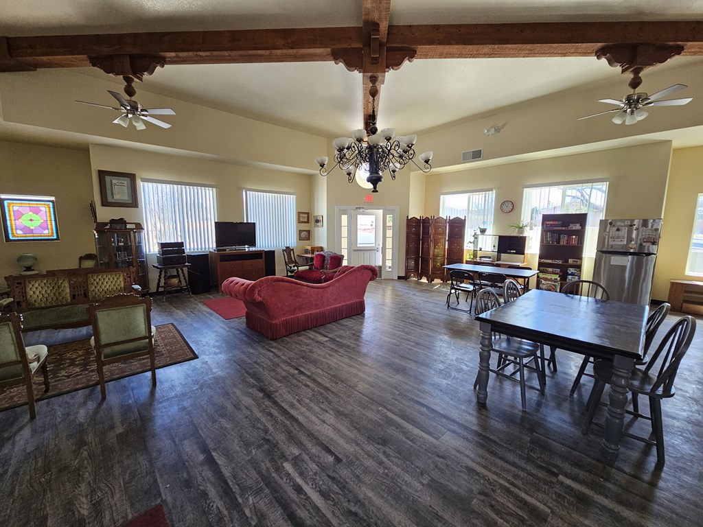 A large room with a wooden floor and a chandelier hanging from the ceiling.