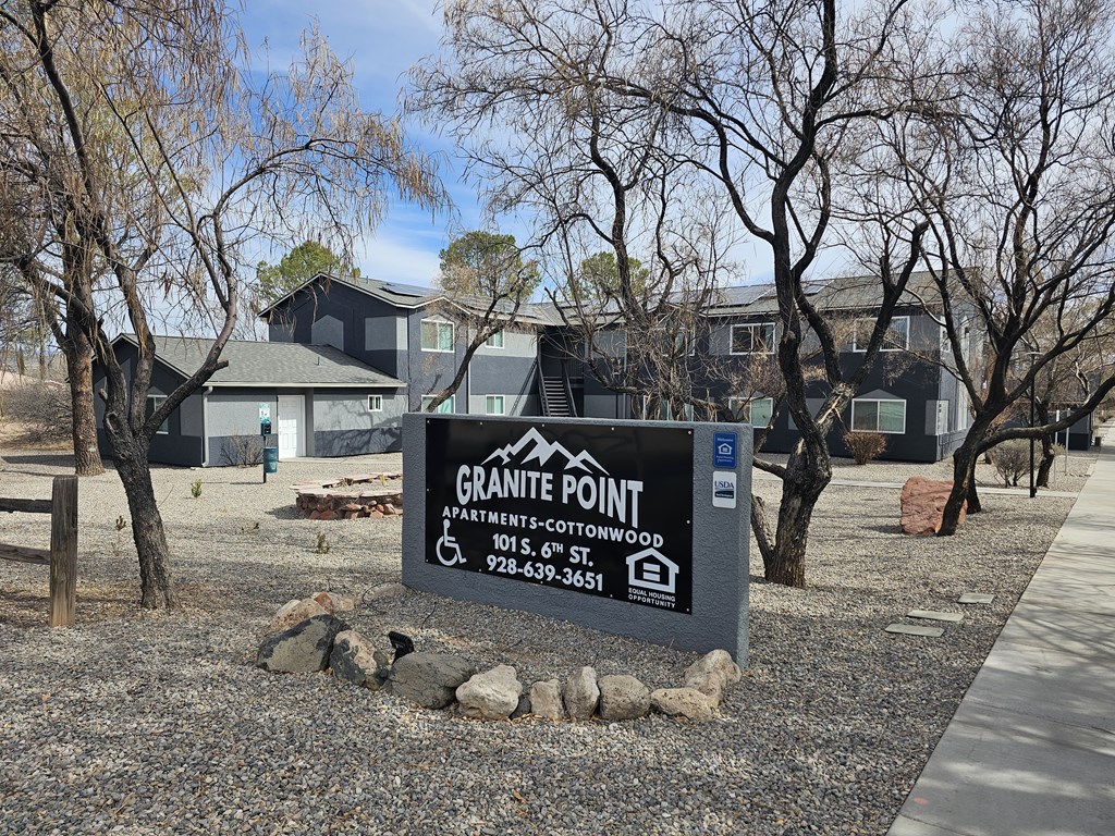 A sign for Granite Point Apartments is in front of some buildings.