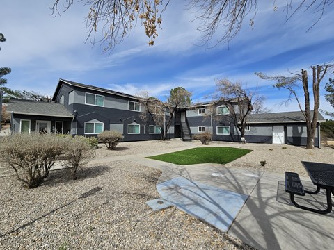 A grey building with a green lawn in front.