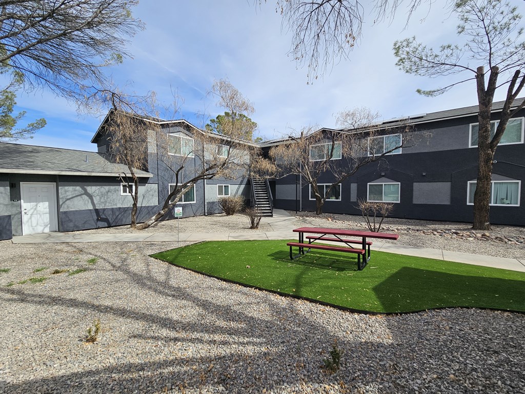 A building with a grey roof and a red bench in front of it.