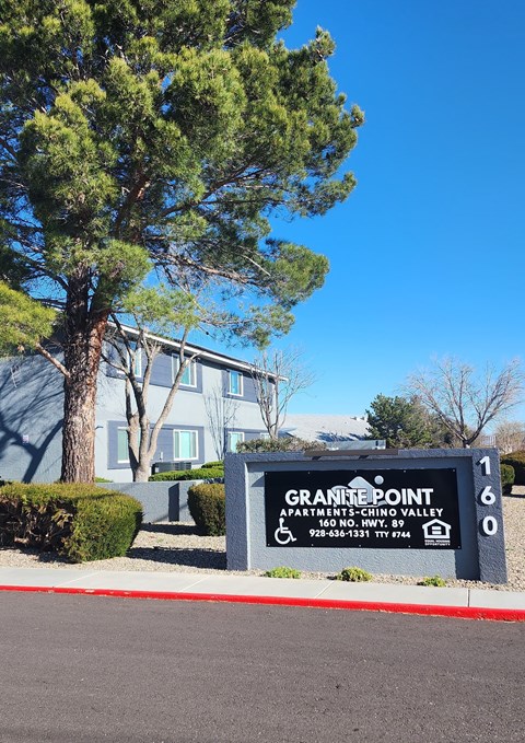 A sign for Granite Point Apartments sits in front of a building.