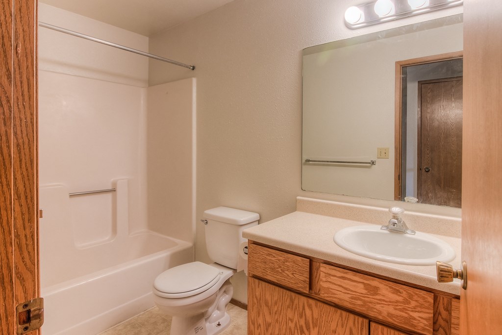 A white toilet sits next to a white sink in a bathroom.