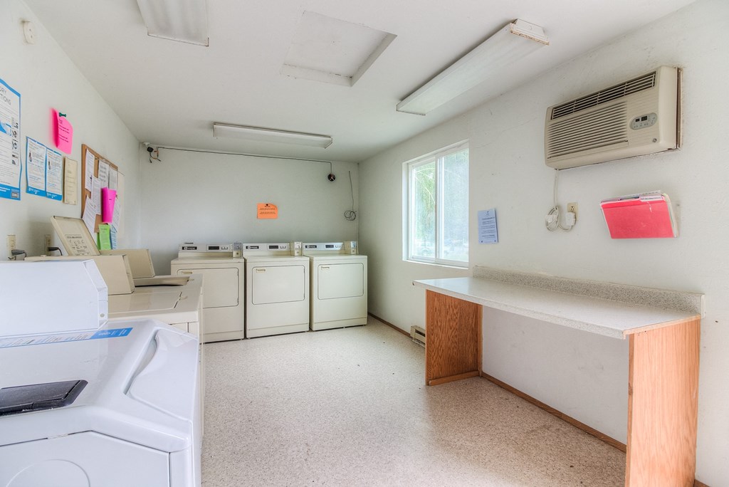 A clean, empty laundry room with washers and dryers.