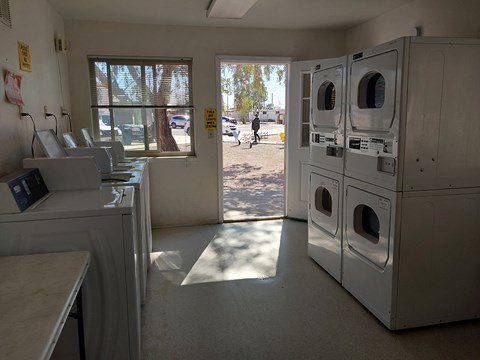 A laundromat with a view of the outside through the window.