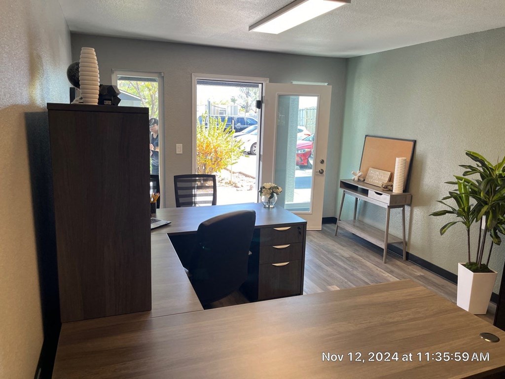 A room with a wooden desk and a black chair.