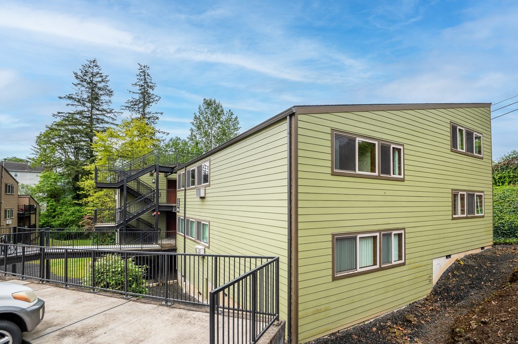 A green house with a black fence in front.