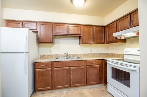A kitchen with wooden cabinets and a white refrigerator.
