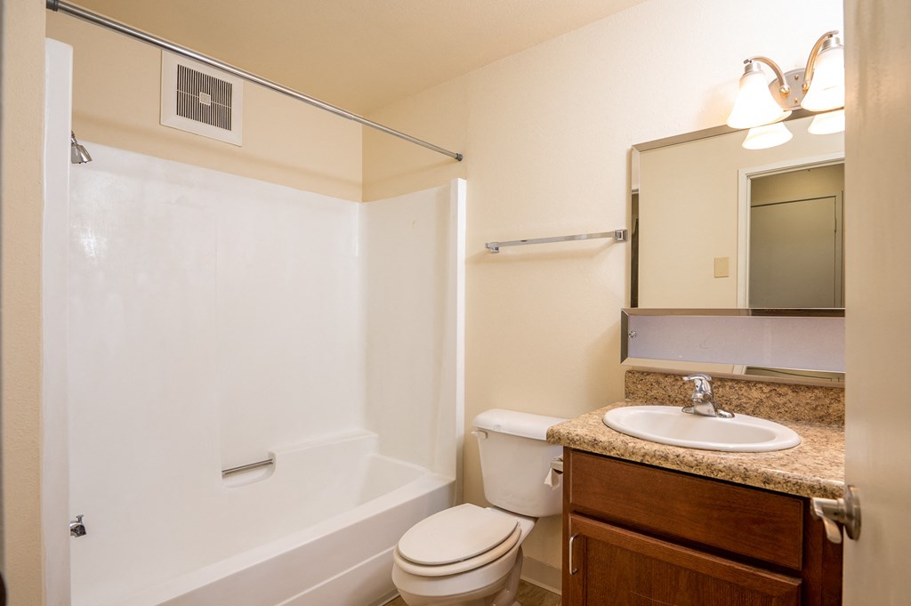 A white bathroom with a toilet, sink, and bathtub.