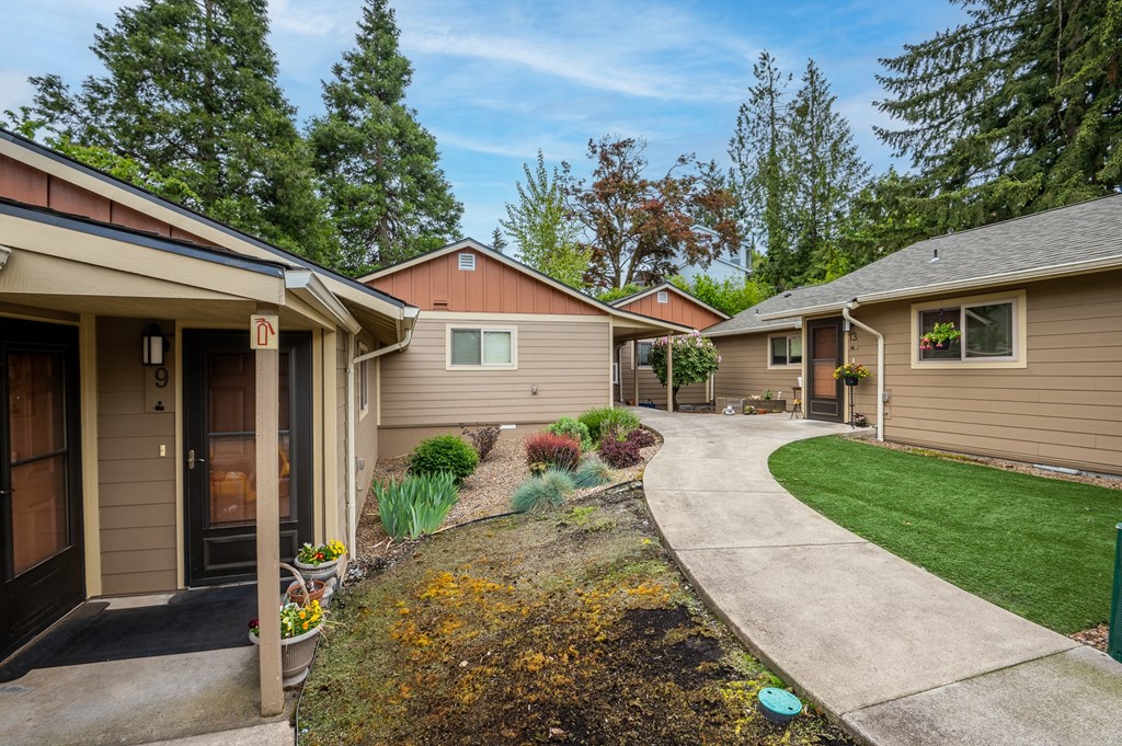 A row of houses with a green lawn in front.