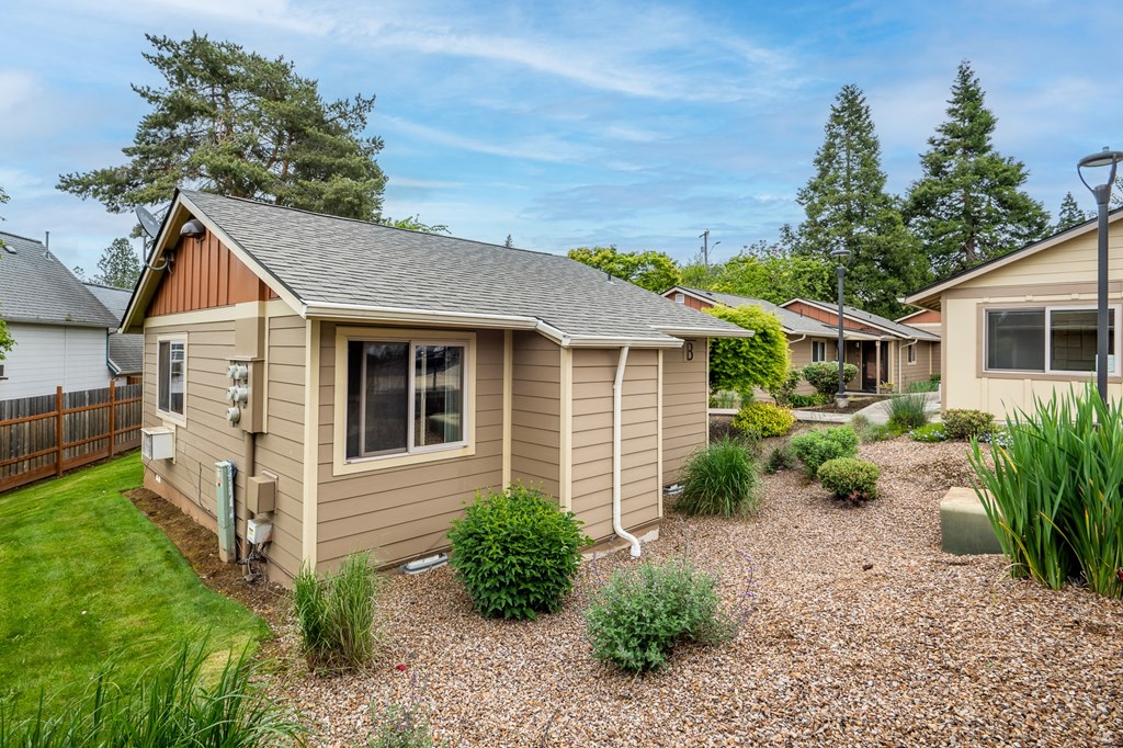 A house with a brown roof and a gravel yard.