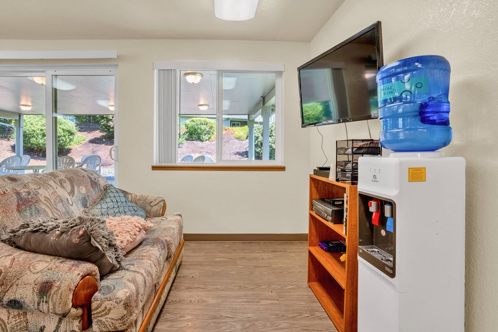 a living room with a couch and a tv and a refrigerator