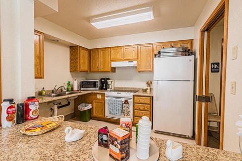 a kitchen with a counter with food and a refrigerator