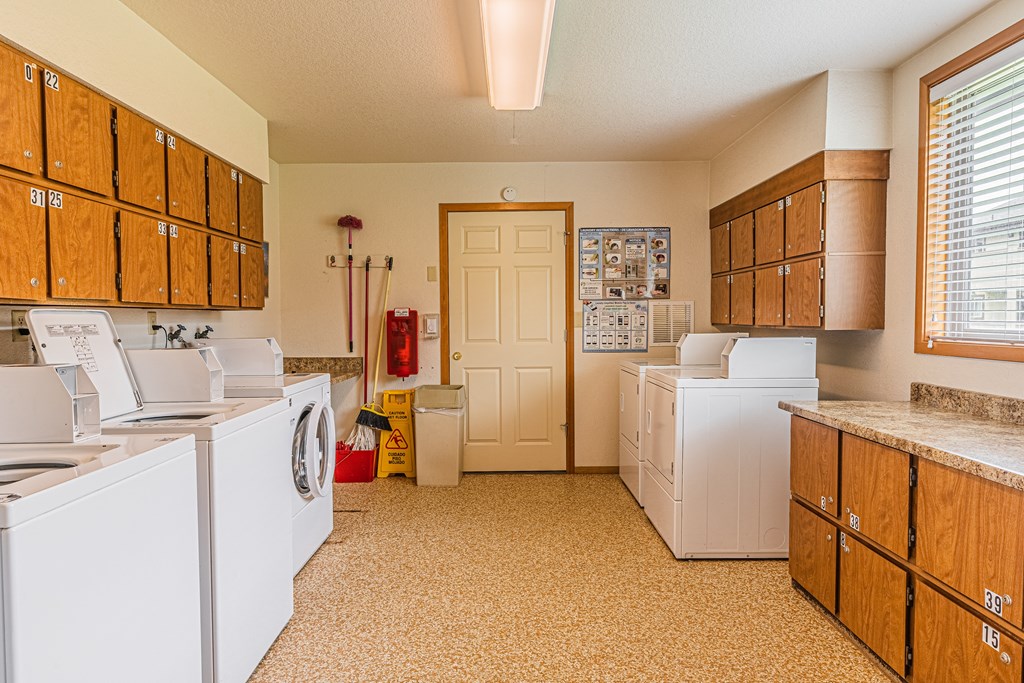 a kitchen with washer and dryers and a door to a closet