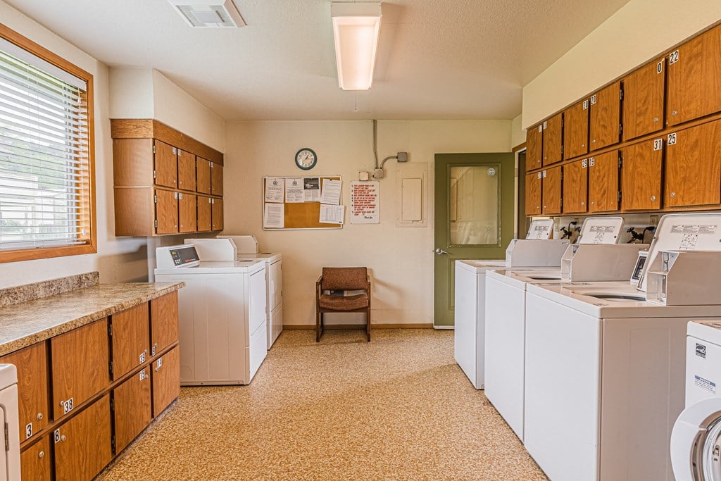a washer and dryer in a laundry room with washing machines and cabinets