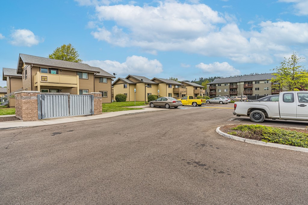an empty parking lot with apartment buildings on the side of it