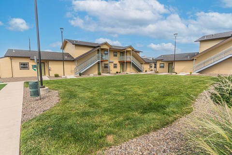 A grassy area in front of a building with a gravel path.