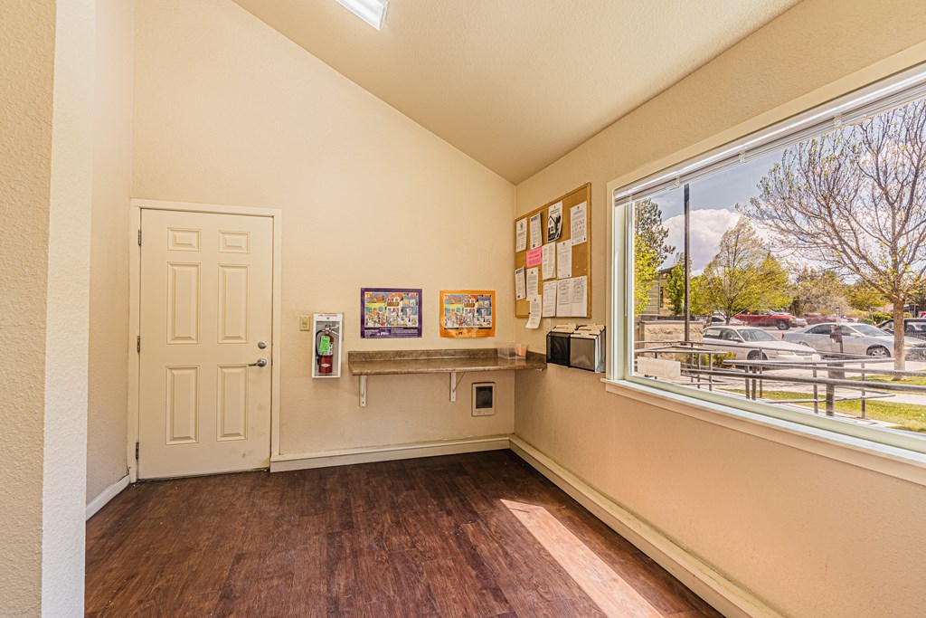 A room with a white door and a bulletin board on the wall.