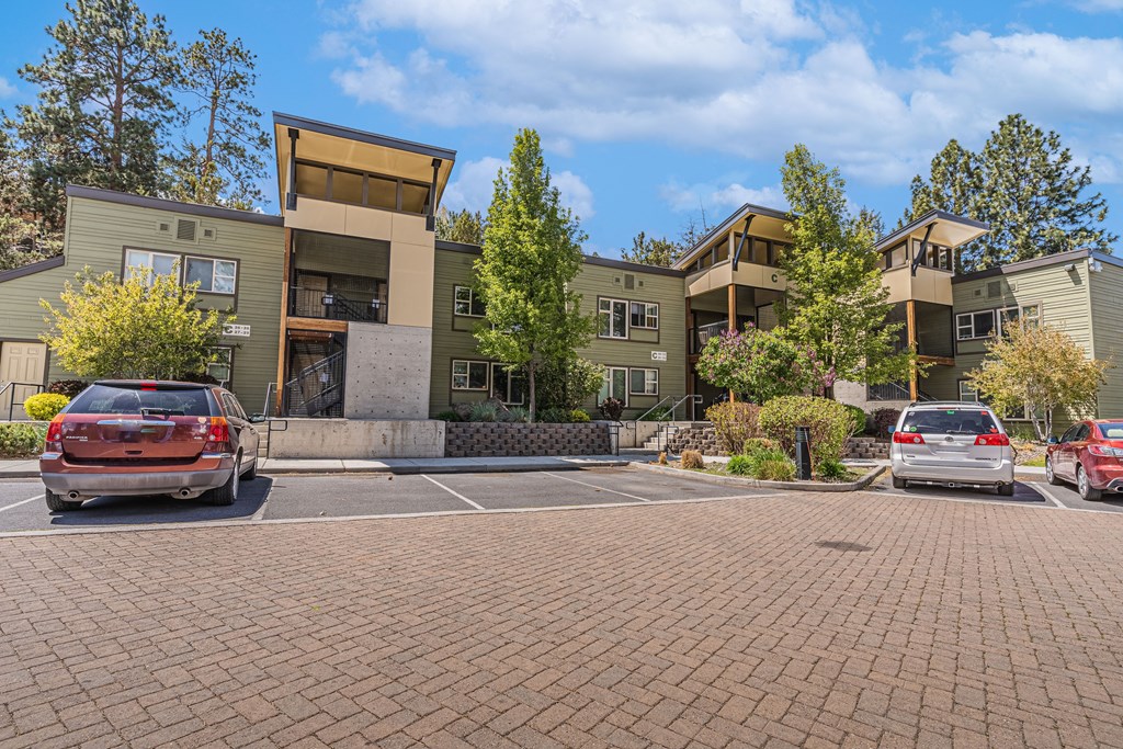 A parking lot with cars and apartment buildings in the background.