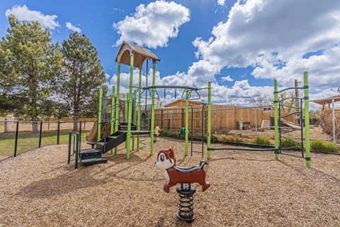 a playground with a monkey statue and a swing set