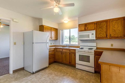 a kitchen with white appliances and wooden cabinets