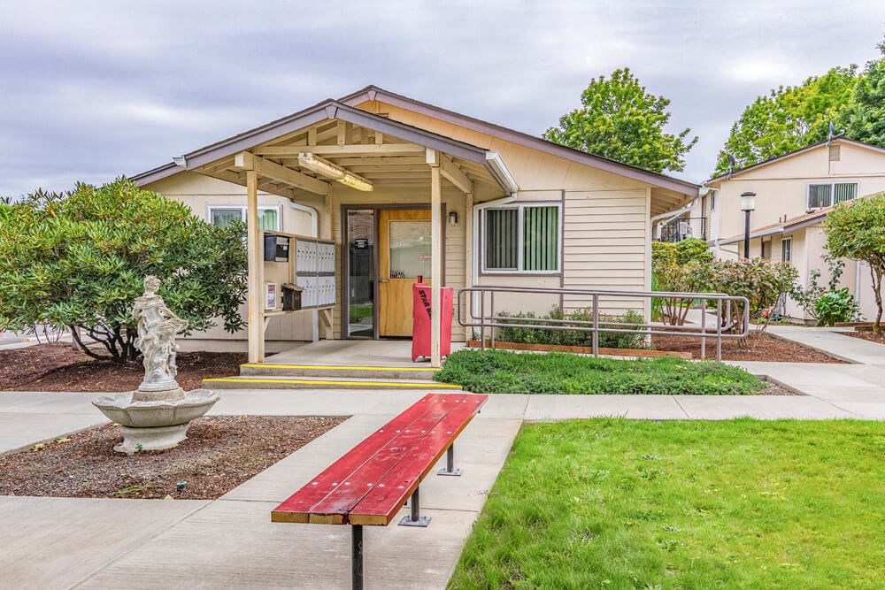 the front of a house with a red bench
