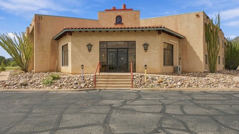 A house with a red tile roof and a stone wall in front.