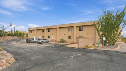 A parking lot with a building and a car.