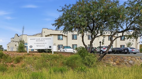 A building with a sign that says Desert Sage Apartments.
