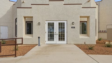A building with a white door and windows with brown frames.