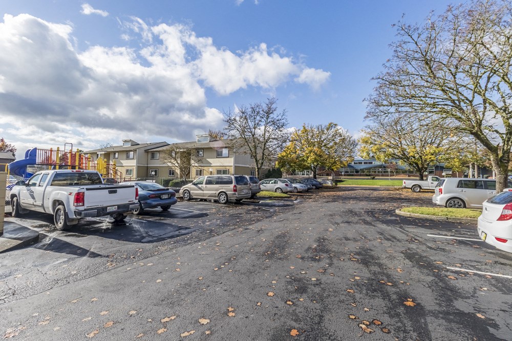 a parking lot with cars in front of a building
