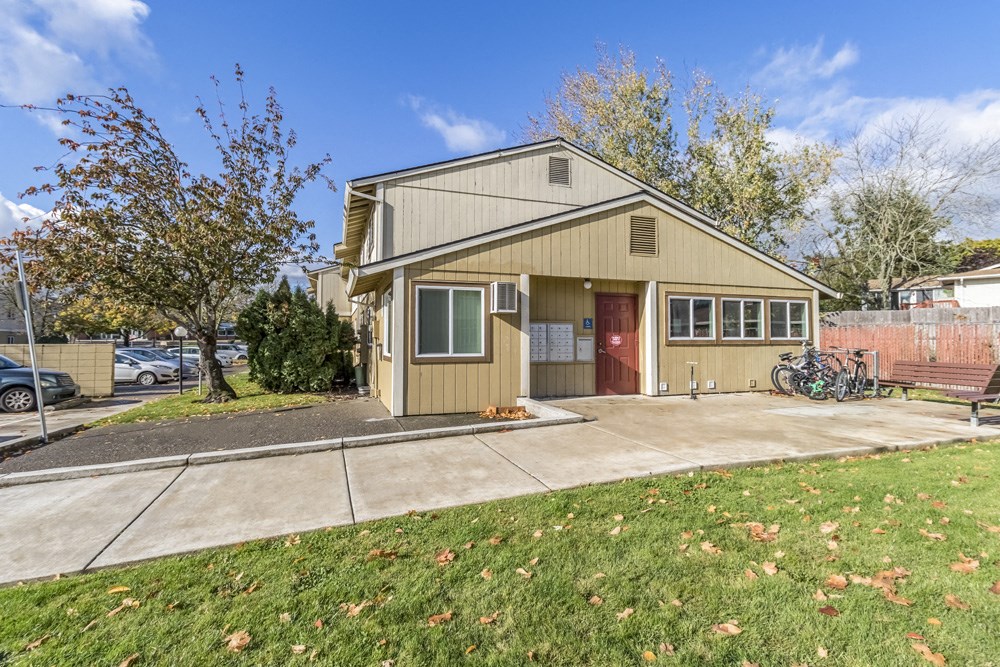 the front of a house with a sidewalk and a bike parked outside