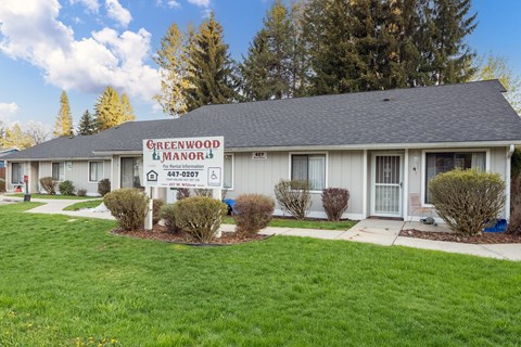 A building with a sign that says Greenwood Manor.