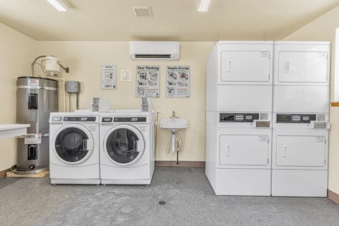 a laundry room with washer and dryers and a sink