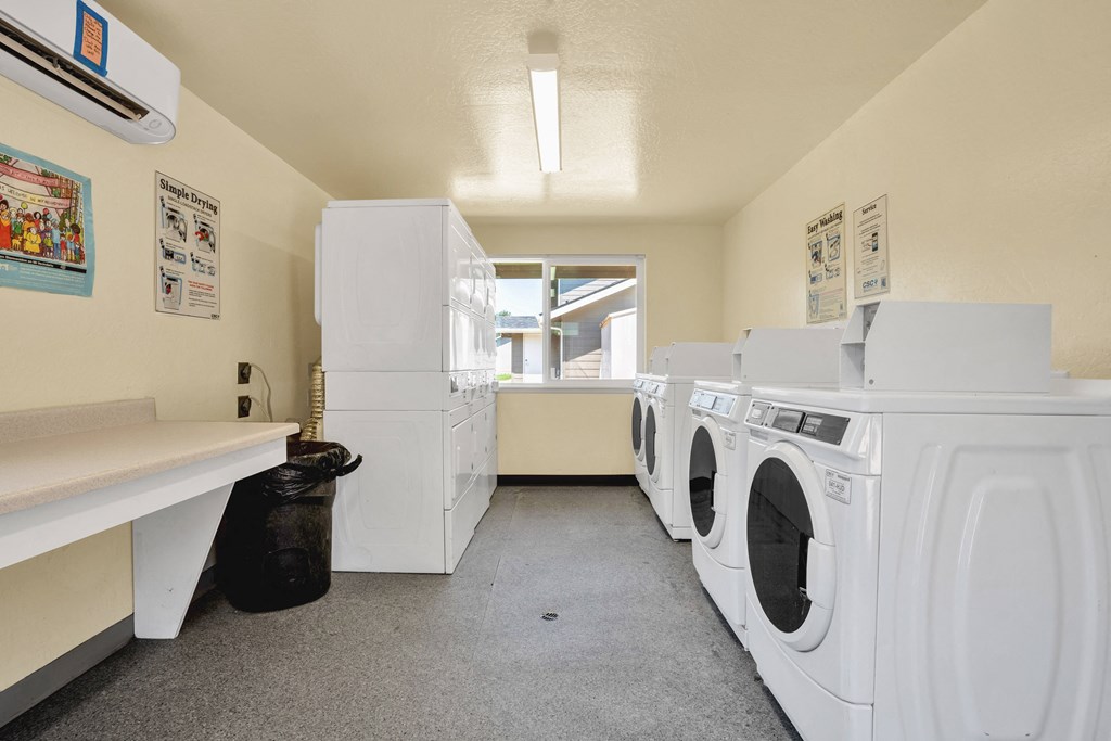 a washer and dryer room in a laundry room with washing machines and sinks